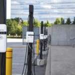 Bornes de recharge SWTCH sur piédestal devant un immeuble de bureaux